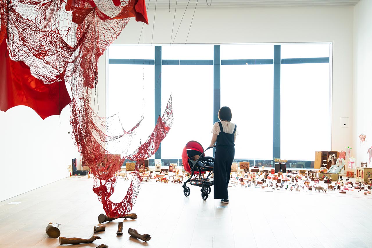 53階の窓からミニチュアのような東京の街が一望できる部屋には、アンティークのミニチュアの家具で構成された《小さな記憶をつなげて》（2019年）。手前は自身の身体をモチーフにした《外在化された身体》（2019年）。