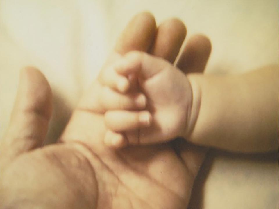 赤ちゃんと父の手