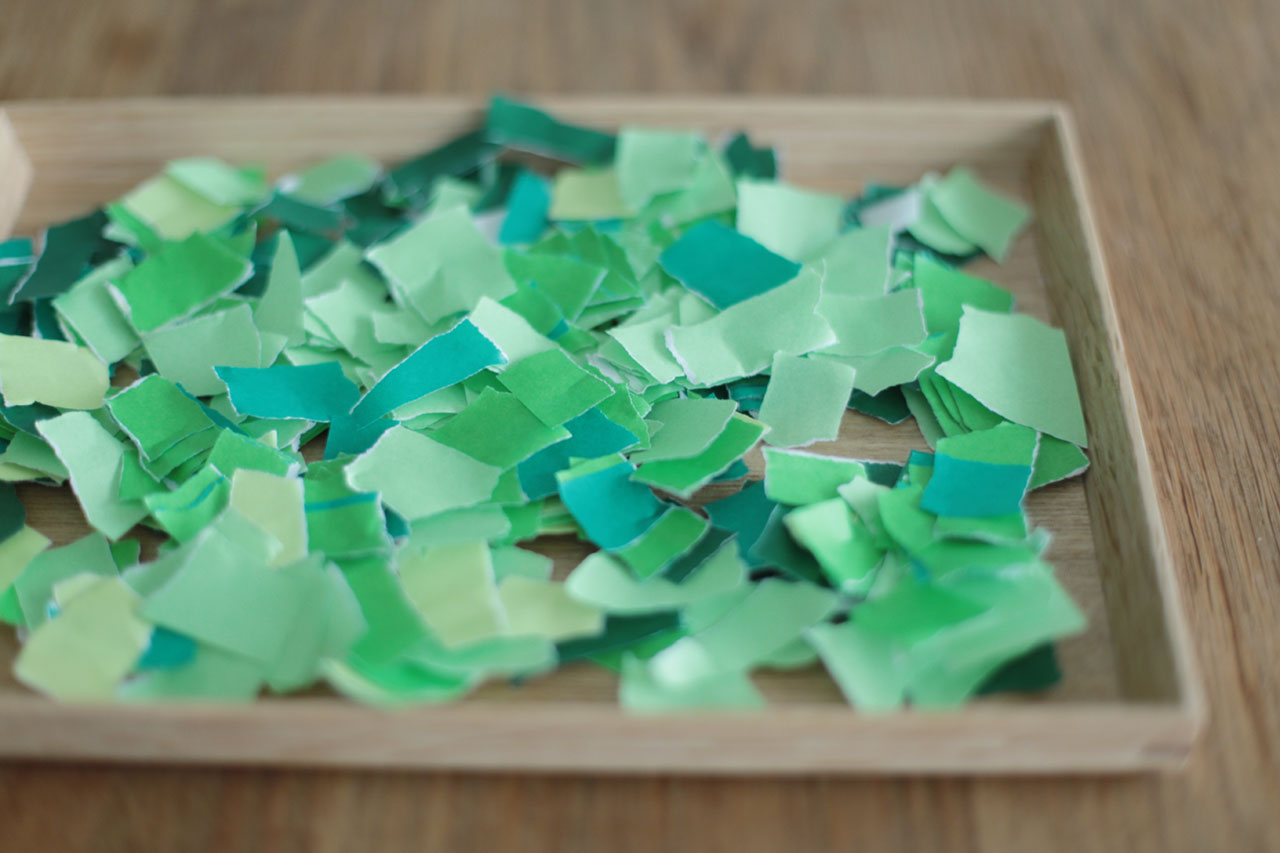 緑の折り紙を小さく手でちぎります