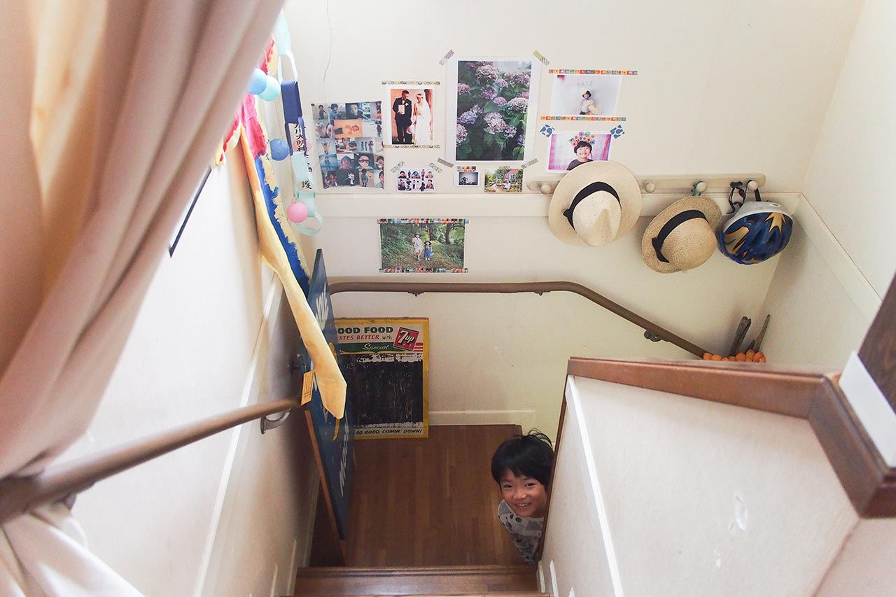 階段に飾っている写真と顔をのぞかせる息子